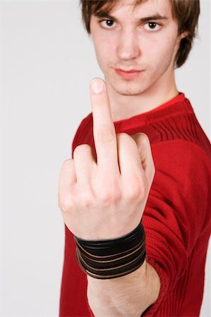 sarcasm - young man giving the finger against white background Stock Photo - Budget Royalty-Free & Subscription, Code: 400-04945053
