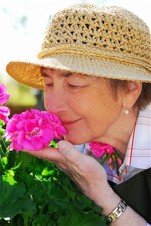 smelling old people - Portrait of a happy senior woman in her garden smelling flowers Stock Photo - Budget Royalty-Free & Subscription, Code: 400-04946491