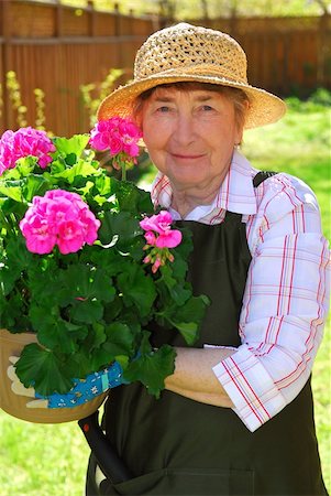 family backyard gardening not barbeque - Senior woman holding a pot with flowers in her garden Stock Photo - Budget Royalty-Free & Subscription, Code: 400-04946844