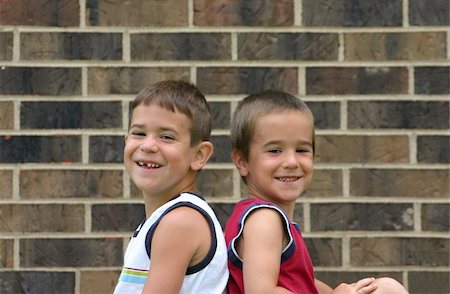 simsearch:400-04449607,k - Brothers Smiling Against a Brick Wall Photographie de stock - Aubaine LD & Abonnement, Code: 400-04947208