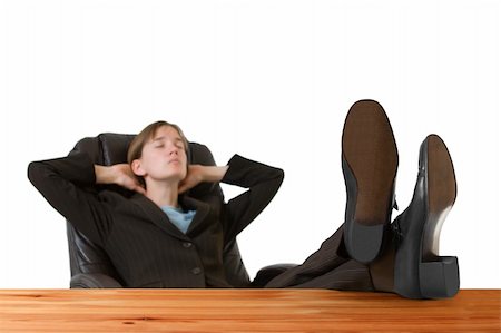 Successful, young business woman in a tailored suit resting with feet up on a desk. Image is isolated on a white background. Stock Photo - Budget Royalty-Free & Subscription, Code: 400-04947903