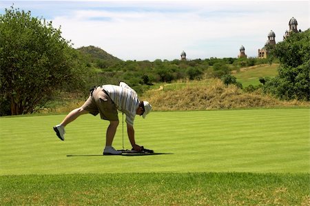 simsearch:400-04942072,k - Golfer picking up the towel on the green. Foto de stock - Royalty-Free Super Valor e Assinatura, Número: 400-04948324