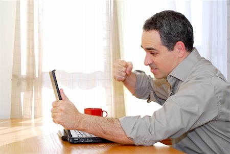 Man sitting at a desk punching his computer in frustration Stock Photo - Budget Royalty-Free & Subscription, Code: 400-04940478
