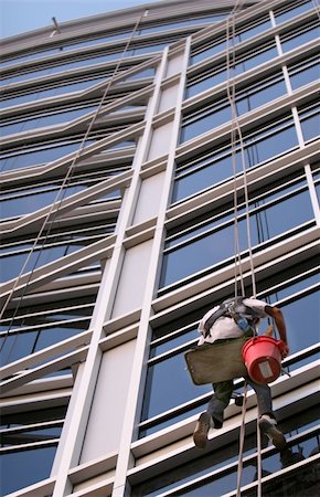A window washer descend on ropes high above the city. The building is a very modern glass structure. Stock Photo - Budget Royalty-Free & Subscription, Code: 400-04940557