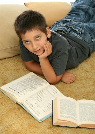 simsearch:400-04434314,k - Boy in a room reading a book over a carpet. Photographie de stock - Aubaine LD & Abonnement, Code: 400-04941920