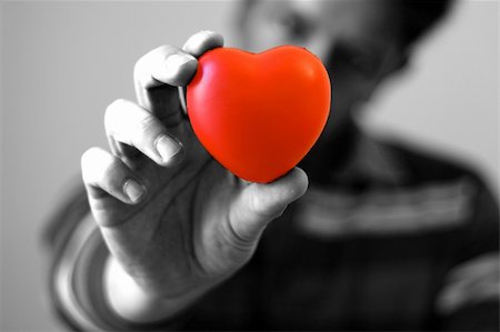 A young man giving is red hear with love (focus on the heart) Stock Photo - Budget Royalty-Free & Subscription, Code: 400-04942496