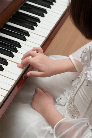 piano practice - Young girl in white dress playing piano Stock Photo - Budget Royalty-Free & Subscription, Code: 400-04943667