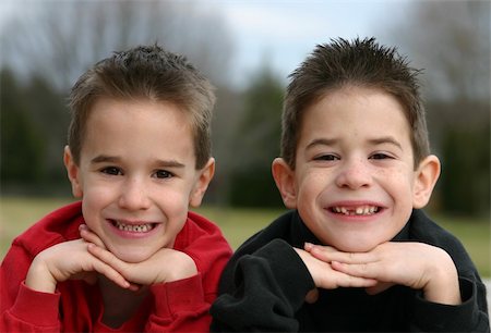 simsearch:400-05875962,k - Two brothers smiling with chin in hands Photographie de stock - Aubaine LD & Abonnement, Code: 400-04943794