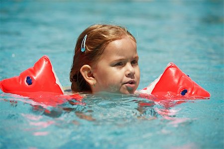 Small girl swimming in pool with water wings Stock Photo - Budget Royalty-Free & Subscription, Code: 400-04955554