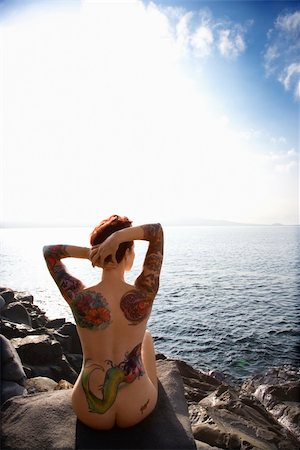 simsearch:695-05776036,k - Sexy nude tattooed Caucasian woman sitting on rock on beach in Maui, Hawaii, USA. Foto de stock - Super Valor sin royalties y Suscripción, Código: 400-04955685