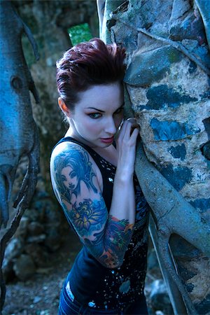 Blue-toned portrait of fearful looking tattooed Caucasian woman next to concrete wall in Maui, Hawaii, USA. Stock Photo - Budget Royalty-Free & Subscription, Code: 400-04955705