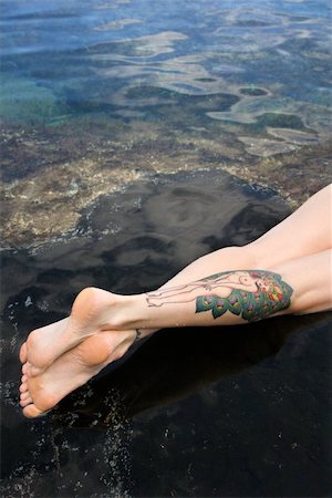 simsearch:400-04450899,k - Legs of tattooed Caucasian woman lying in tidal pool in Maui, Hawaii, USA. Stock Photo - Budget Royalty-Free & Subscription, Code: 400-04955744