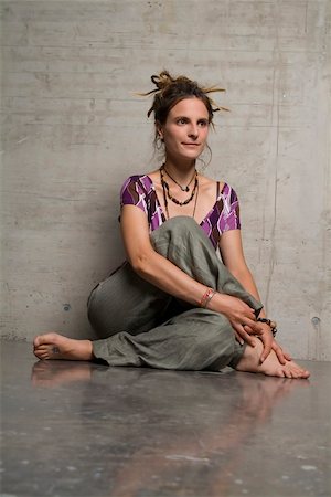 a ayoung woman with readlocks is sitting on a concrete floor Foto de stock - Super Valor sin royalties y Suscripción, Código: 400-04956244