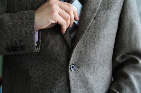 Smartly dressed business man putting a credit card into his pocket. Stock Photo - Budget Royalty-Free & Subscription, Code: 400-04956334