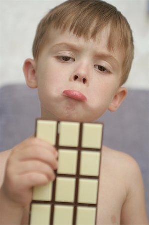 Emotions of the child with chocolate in a hand Stockbilder - Microstock & Abonnement, Bildnummer: 400-04956521
