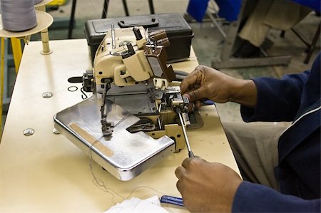 African American man repairing the overlock machine, industrial series Stock Photo - Budget Royalty-Free & Subscription, Code: 400-04956718