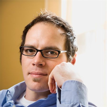 simsearch:400-03926822,k - Caucasian mid adult man wearing glasses and looking at viewer with hand to face. Stock Photo - Budget Royalty-Free & Subscription, Code: 400-04957408