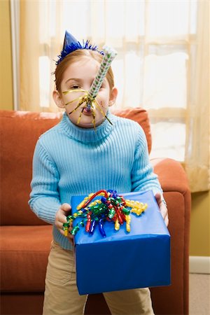 simsearch:693-07444529,k - Caucasian girl blowing noisemaker and holding gift. Stock Photo - Budget Royalty-Free & Subscription, Code: 400-04957423