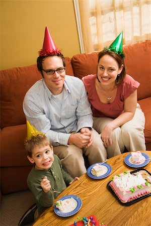 Caucasian boy and parents in party hats eating birthday cake. Stock Photo - Budget Royalty-Free & Subscription, Code: 400-04957436