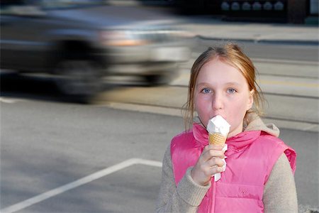 people eating food in street - Young girl eating ice cream, moving car in the background Stock Photo - Budget Royalty-Free & Subscription, Code: 400-04958786