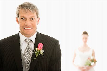 simsearch:400-04950359,k - Caucasian groom in foreground with scared expression and Asian bride in background. Stock Photo - Budget Royalty-Free & Subscription, Code: 400-04950346