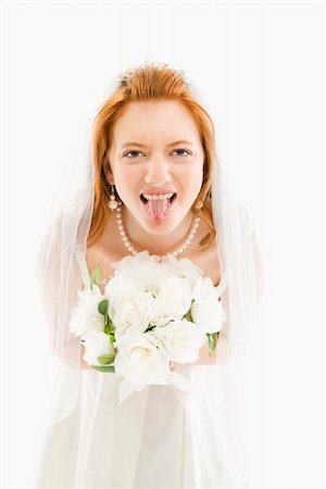 simsearch:400-04950359,k - Portrait of Caucasian bride holding bouquet and sticking her tongue out Stock Photo - Budget Royalty-Free & Subscription, Code: 400-04950354