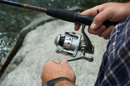 spartika (artist) - A fisherman lets his lure sink a little before reeling it in, in an attempt to catch a fish with his spin reel. Stock Photo - Budget Royalty-Free & Subscription, Code: 400-04950364