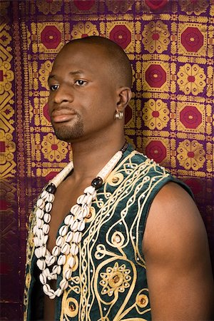 embroidery for male clothes - Side view portrait of African-American mid-adult man wearing embroidered African vest and beads. Photographie de stock - Aubaine LD & Abonnement, Code: 400-04950468