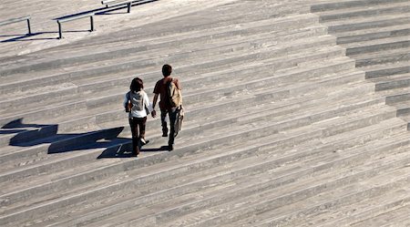 people walking in the stairs and hand - two peoples with long shadows walking on the wooden stairs Stock Photo - Budget Royalty-Free & Subscription, Code: 400-04950647