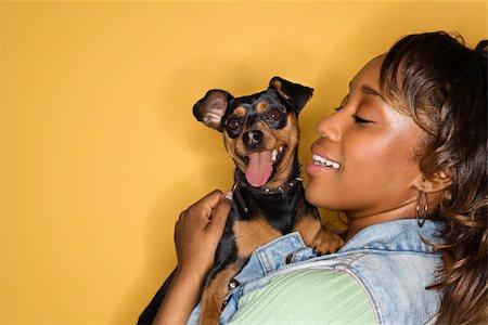 simsearch:400-04446187,k - African American young adult female holding Miniature Pinscher dog. Photographie de stock - Aubaine LD & Abonnement, Code: 400-04951097