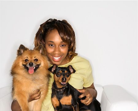 simsearch:400-04446187,k - African American young adult female holding brown Pomeranian and Miniature Pinscher dogs. Photographie de stock - Aubaine LD & Abonnement, Code: 400-04951098
