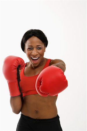 African American young adult woman wearing boxing goves throwing playful punch at viewer. Stock Photo - Budget Royalty-Free & Subscription, Code: 400-04951189