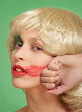 simsearch:400-04736335,k - A beautiful girl in a wig. She smears lipstick on the face Photographie de stock - Aubaine LD & Abonnement, Code: 400-04952718
