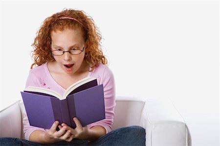 simsearch:400-03923096,k - Caucasian female child sitting reading book looking surprised. Stock Photo - Budget Royalty-Free & Subscription, Code: 400-04952988