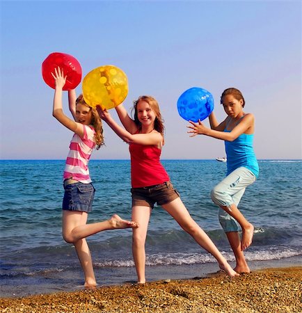Three girls with colorful beach balls walking on sea shore Photographie de stock - Aubaine LD & Abonnement, Code: 400-04953429