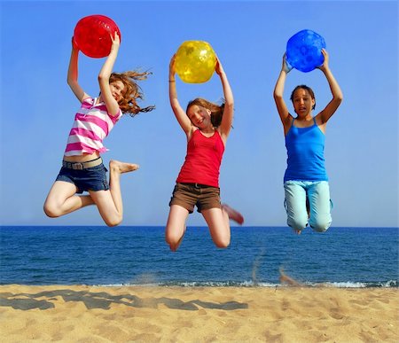 Three girls with colorful beach balls jumping on a seashore Stock Photo - Budget Royalty-Free & Subscription, Code: 400-04953430