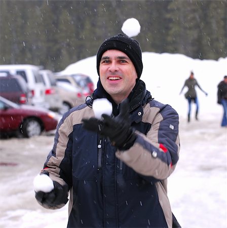 Happy man juggling snowballs in winter park Photographie de stock - Aubaine LD & Abonnement, Code: 400-04953444