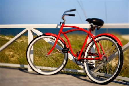 simsearch:400-04953081,k - Red beach cruiser bicycle leaning against walkway rail on beach on Bald Head Island, North Carolina. Foto de stock - Royalty-Free Super Valor e Assinatura, Número: 400-04953578