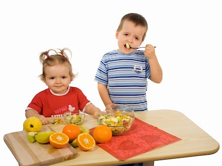 Children, girl and boy, eating fruit salad (isolated) Photographie de stock - Aubaine LD & Abonnement, Code: 400-04964127