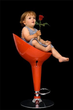 diverse families - Little girl sitting on red swivel chair, offering a rose to someone - concept for mothers day - isolated on black Foto de stock - Super Valor sin royalties y Suscripción, Código: 400-04964217
