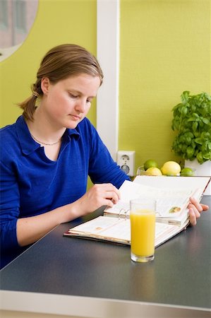A young woman in the kitchen looking at recipes. Stock Photo - Budget Royalty-Free & Subscription, Code: 400-04964914