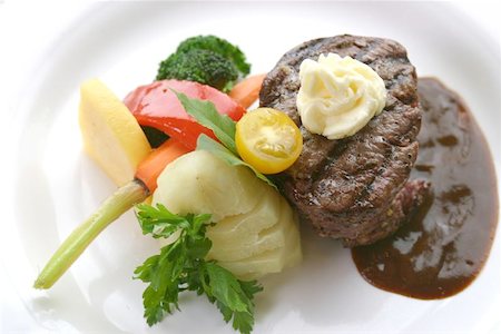 8 oz tenderloin steak dinner with an accompaniment of mashed potatoes, tomatoes, broccoli and butter. Shallow DOF. Stock Photo - Budget Royalty-Free & Subscription, Code: 400-04965682