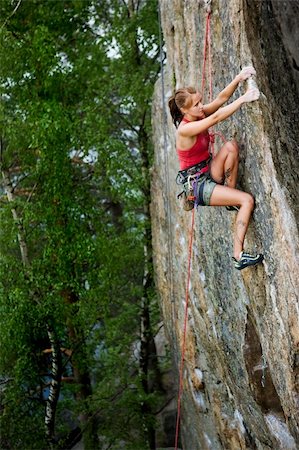 simsearch:400-04441774,k - An eager female climber on a steep rock face looks for the next hold. Shallow depth of field is used to isolated the climber with the focus on the head. Stock Photo - Budget Royalty-Free & Subscription, Code: 400-04966429