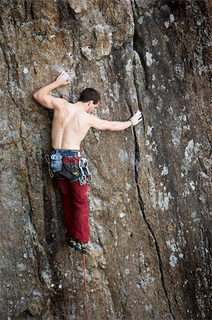 simsearch:400-04463866,k - A male climber against a large rock face climbing lead. Stockbilder - Microstock & Abonnement, Bildnummer: 400-04966431