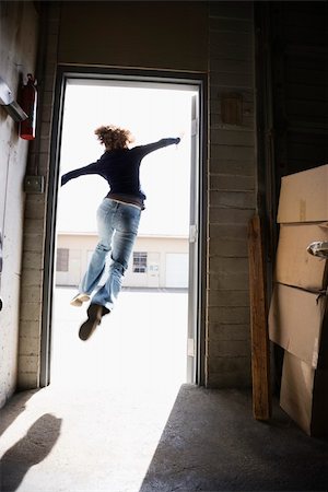 Woman running and jumping through open door from building to sunny outside. Stock Photo - Budget Royalty-Free & Subscription, Code: 400-04967477