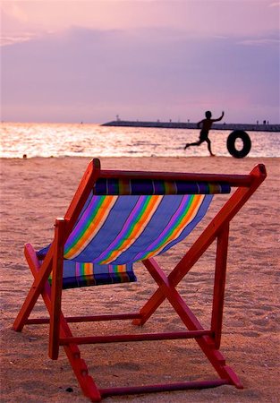 Relax  Chair in foreground with kid running in the background  Location:Pattaya, Thailand Stock Photo - Budget Royalty-Free & Subscription, Code: 400-04967617