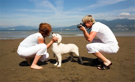 smiley face on beach - young couple on the beach with dog in taking pictures Stock Photo - Budget Royalty-Free & Subscription, Code: 400-04960672