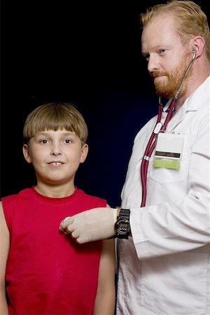 simsearch:400-04508758,k - Doctor using a stethoscope with young child patient on a dark background Foto de stock - Super Valor sin royalties y Suscripción, Código: 400-04960940