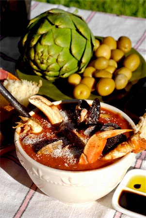 Traditional San Francisco meal of a bowl of cioppino, artichokes and fresh sourdough bread set outdoors on a vintage tablecloth.  Cioppino was created in the early 1900's by fisherman on the wharfs of San Francisco, California, who "chipped in" their daily catch for an end-of-the-day meal. Stock Photo - Budget Royalty-Free & Subscription, Code: 400-04961094