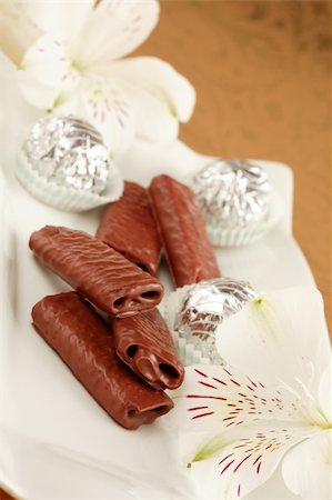 simsearch:400-05173188,k - Sweet chocolate rolls on the plate decoraed with flowers Stock Photo - Budget Royalty-Free & Subscription, Code: 400-04961418